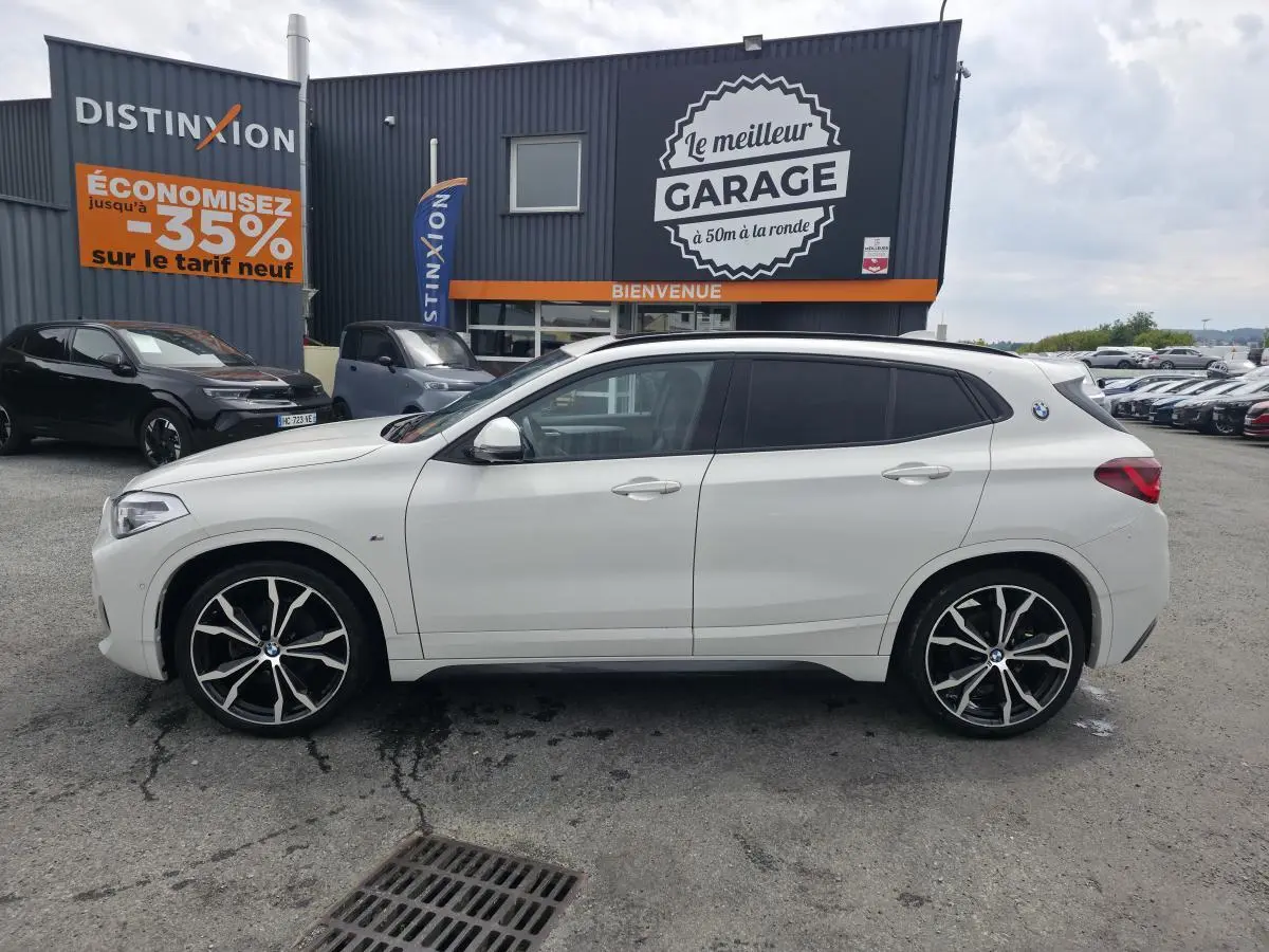 BMW X2 sDrive 18d blanc vue de profil côté gauche avec jantes M Sport noires à rayons doubles.