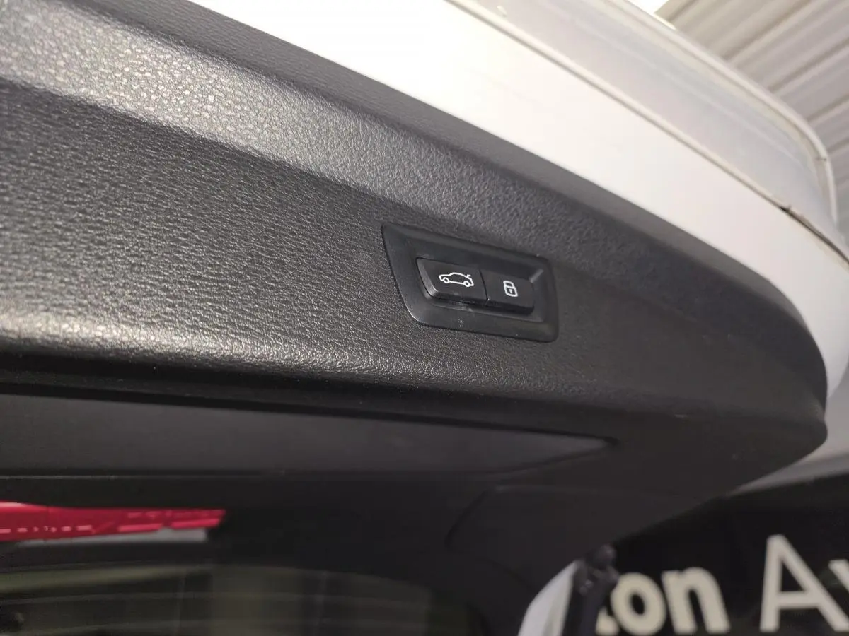 Bouton de commande électrique du hayon sur la bordure intérieure du coffre d’une BMW X2 blanche.