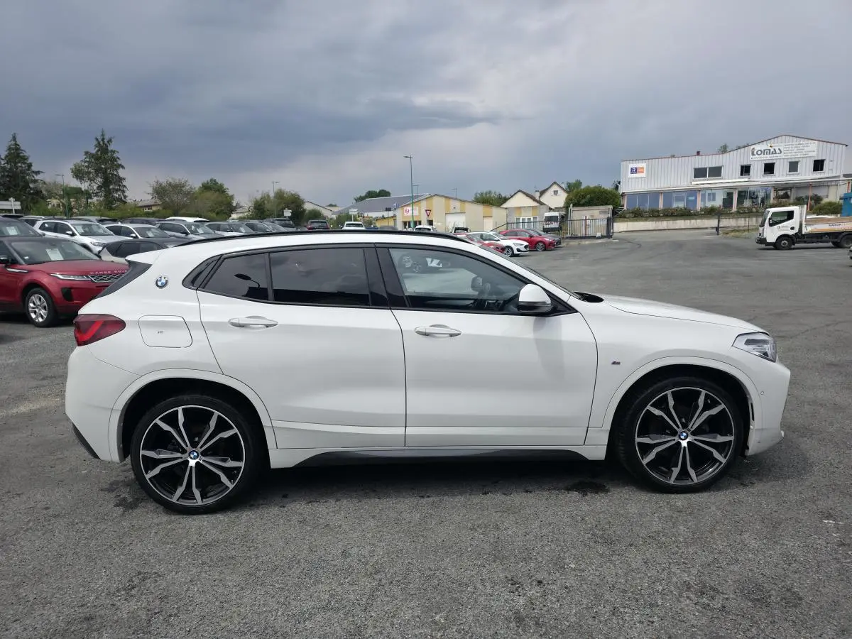 BMW X2 sDrive 18d M Sport blanc vue de profil côté gauche avec jantes alliage noir et détails M Sport.