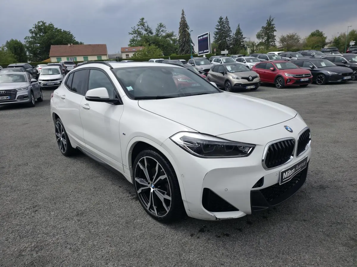 BMW X2 sDrive 18d blanc vue 3/4 avant droit avec jantes alliage 20'' style M et calandre noire sportive.