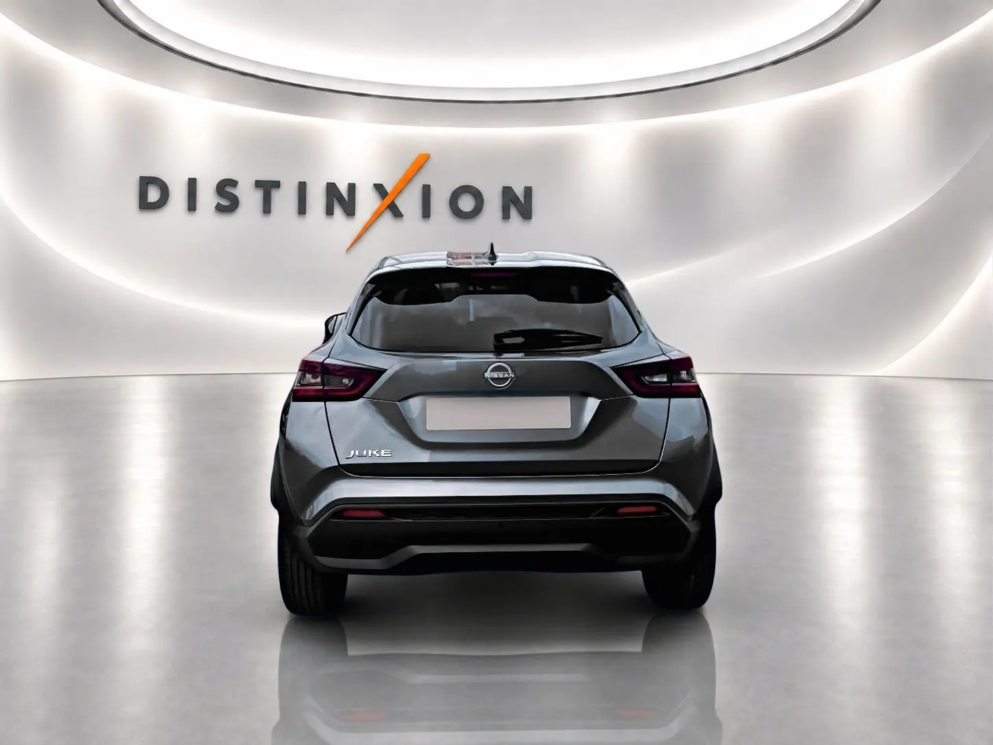Vue arrière d'un Nissan Juke gris 2025 dans un studio lumineux avec logo Distinxion en arrière-plan.