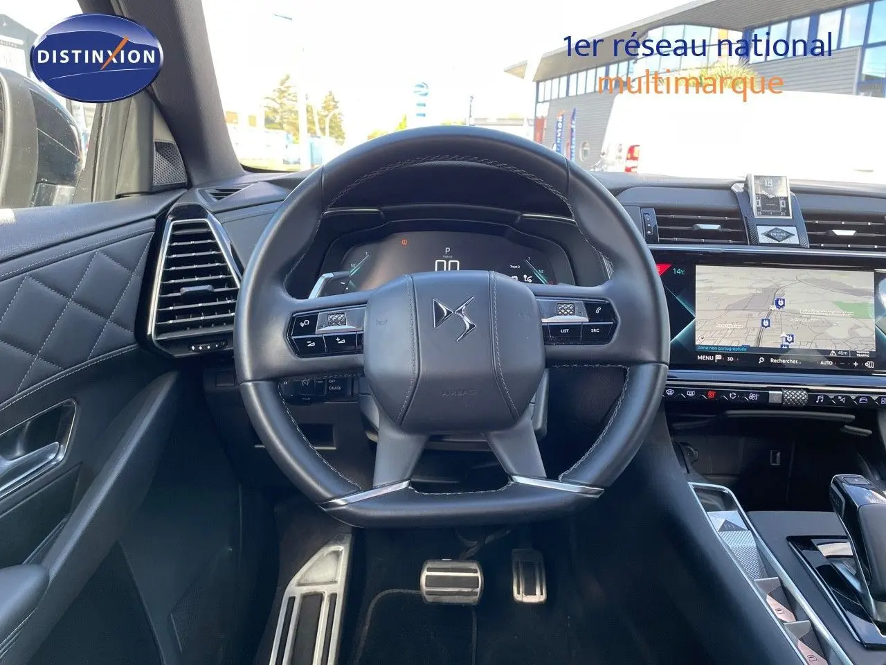 Vue intérieure centrée sur le volant cuir noir du DS7 Crossback E-TENSE 2021 avec tableau de bord digital et écran tactile GPS.