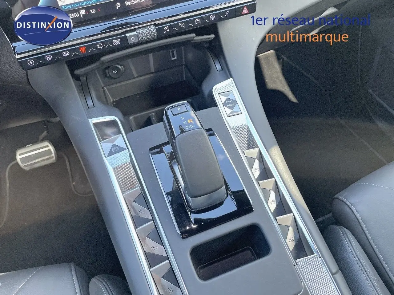 Vue rapprochée de la console centrale du DS7 Crossback E-TENSE 2021, avec levier de vitesse et boutons argentés en losange.