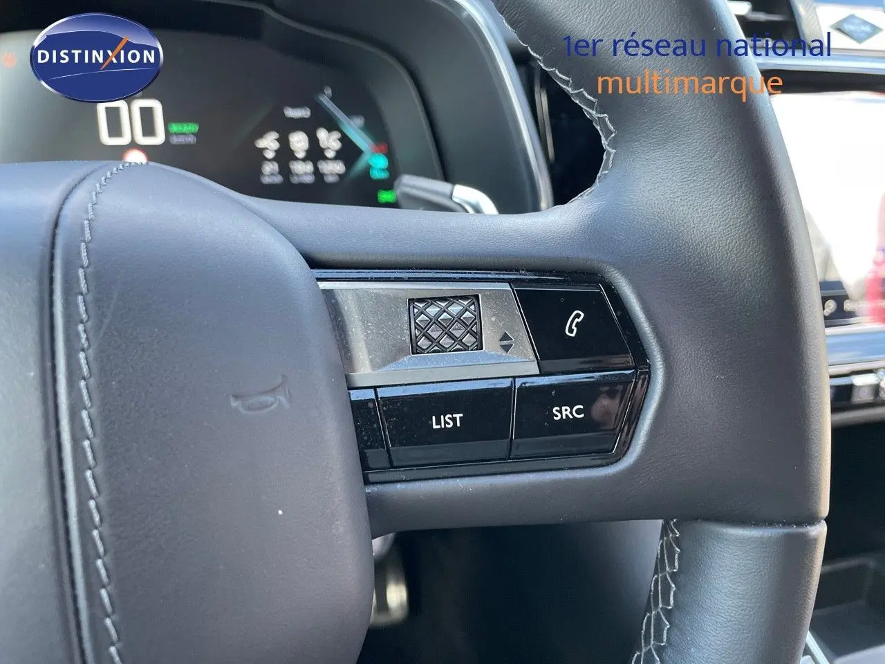 Gros plan sur la partie droite du volant en cuir noir du DS7 Crossback E-TENSE 2021, avec commandes intégrées et tableau de bord numérique en arrière-plan.