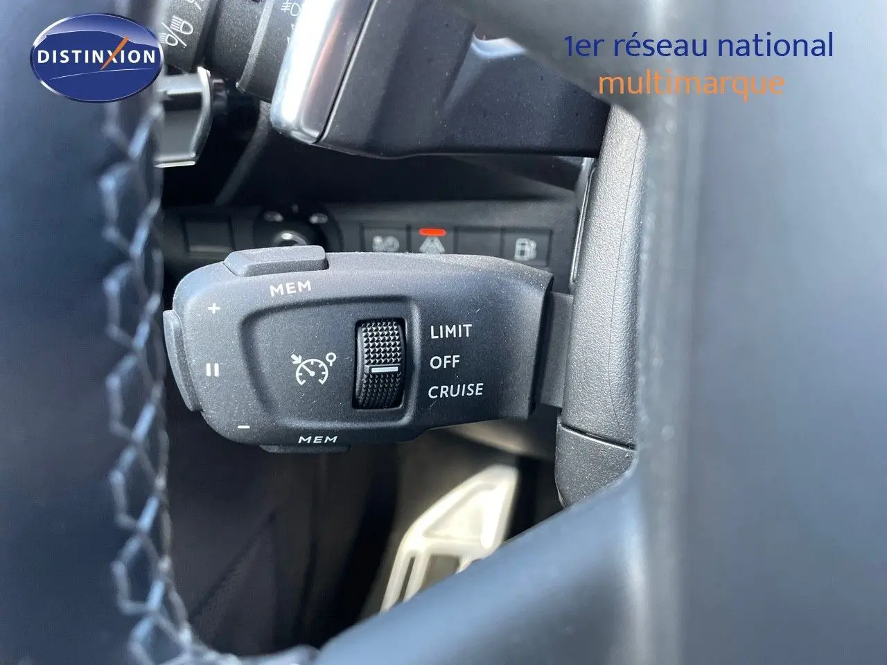 Gros plan sur la commande de régulateur de vitesse au volant d’un DS7 Crossback noir perle métal, intérieur noir.