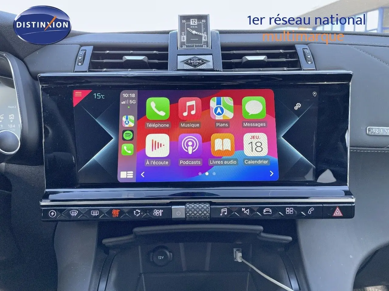 Vue intérieure centrée sur l'écran tactile multimédia du DS7 Crossback noir perle métal avec horloge digitale au-dessus.