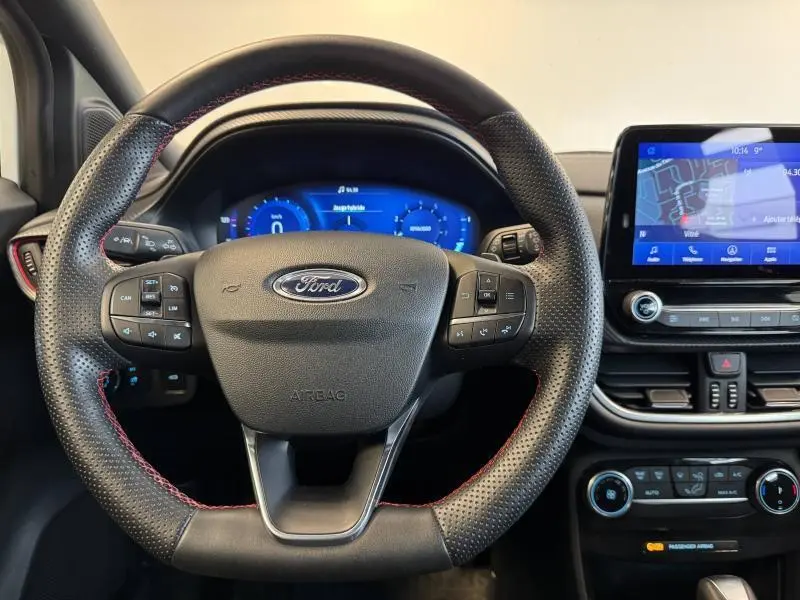 Intérieur du Ford Puma 2022 montrant le volant sport en cuir perforé avec surpiqûres rouges et écran tactile central.