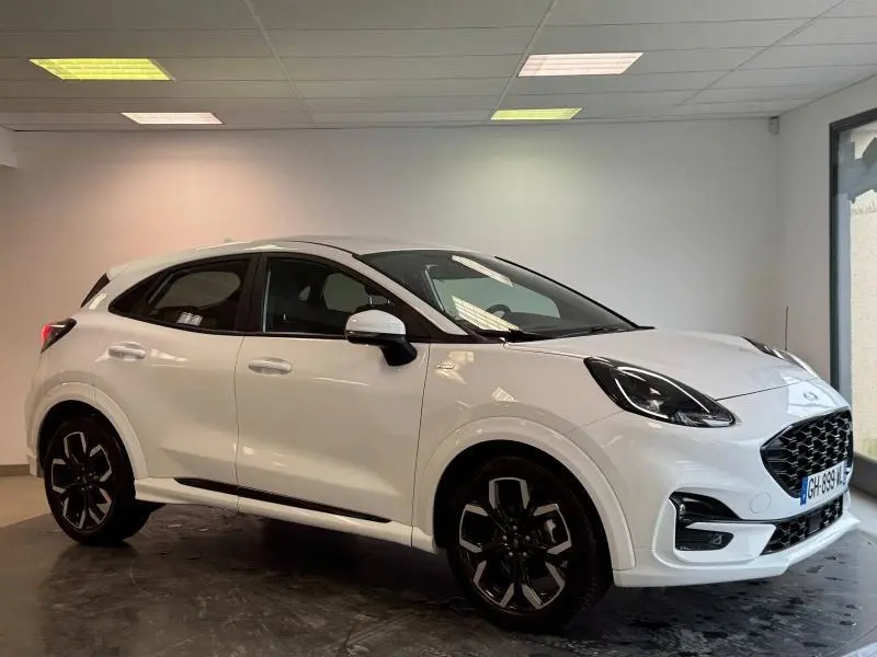 Vue 3/4 avant droit du Ford Puma blanc Glacier, soulignant ses jantes noires et son design compact moderne.