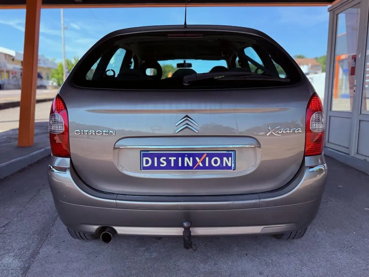 Vue arrière d'une Citroën Xsara Picasso beige 2009 avec attelage de remorque visible sous le pare-chocs.