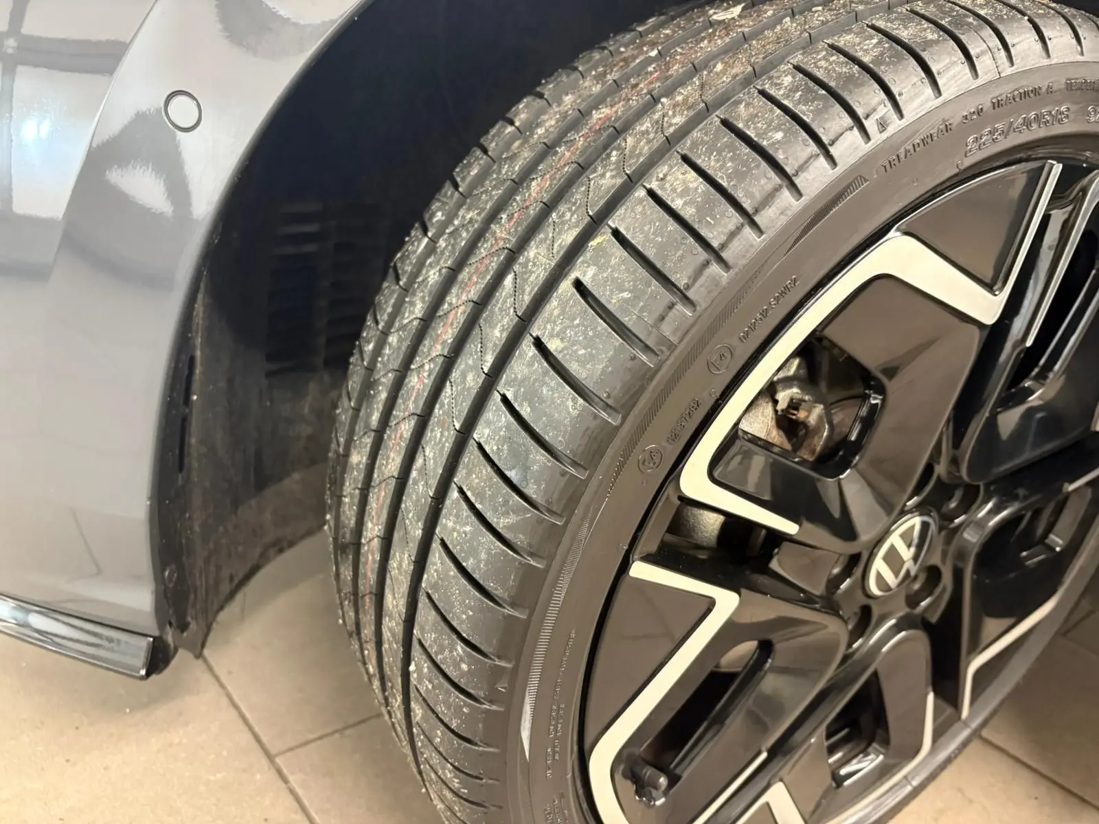 Gros plan sur la roue avant droite d'une Volkswagen Golf 1.5 eTSI 150 DSG7 R-Line Edition gris dauphin avec jante noire et argent.