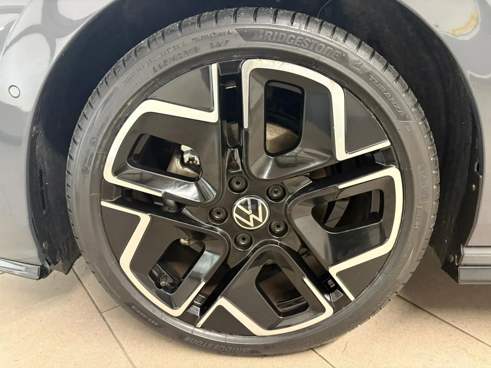 Gros plan sur la jante noire et argentée d’une Volkswagen Golf 1.5 eTSI 150 DSG7 R-Line Edition gris dauphin.