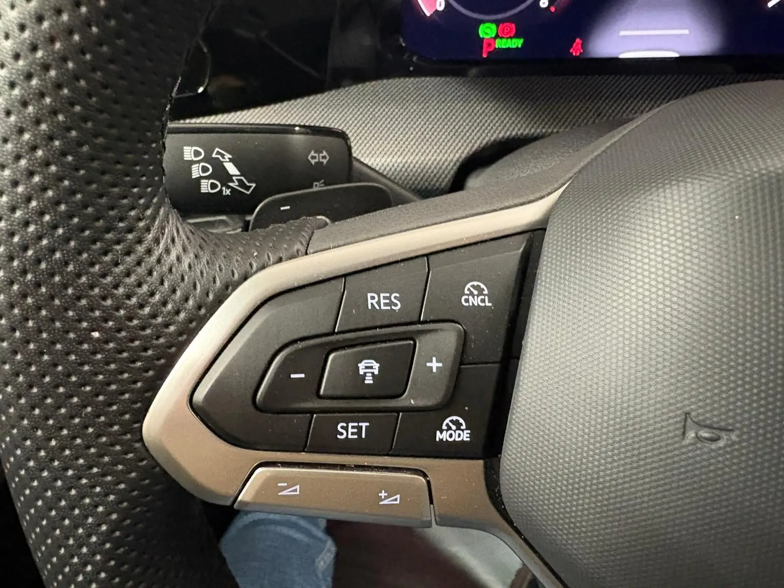 Gros plan sur les commandes de régulateur de vitesse au volant d’une Volkswagen Golf 1.5 eTSI gris Dauphin, 2025.