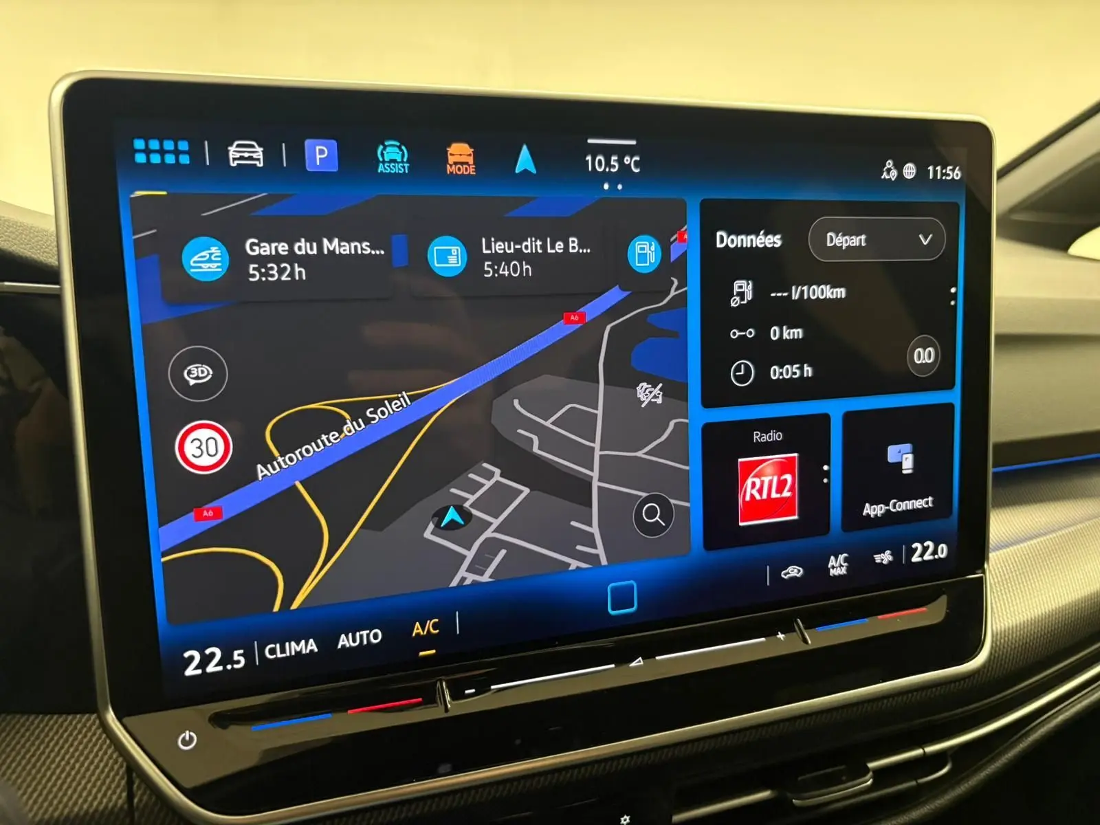 Écran tactile central de la Volkswagen Golf 1.5 eTSI 2025 affichant la navigation et la climatisation, intérieur gris.