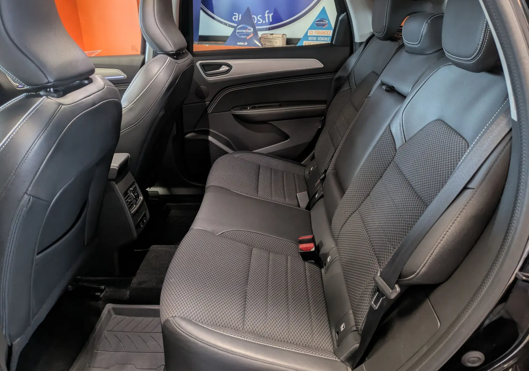Vue intérieure côté droit des sièges arrière en cuir noir du Renault Arkana 1.6 E-Tech hybride 2023, avec ceintures et appuie-têtes visibles.