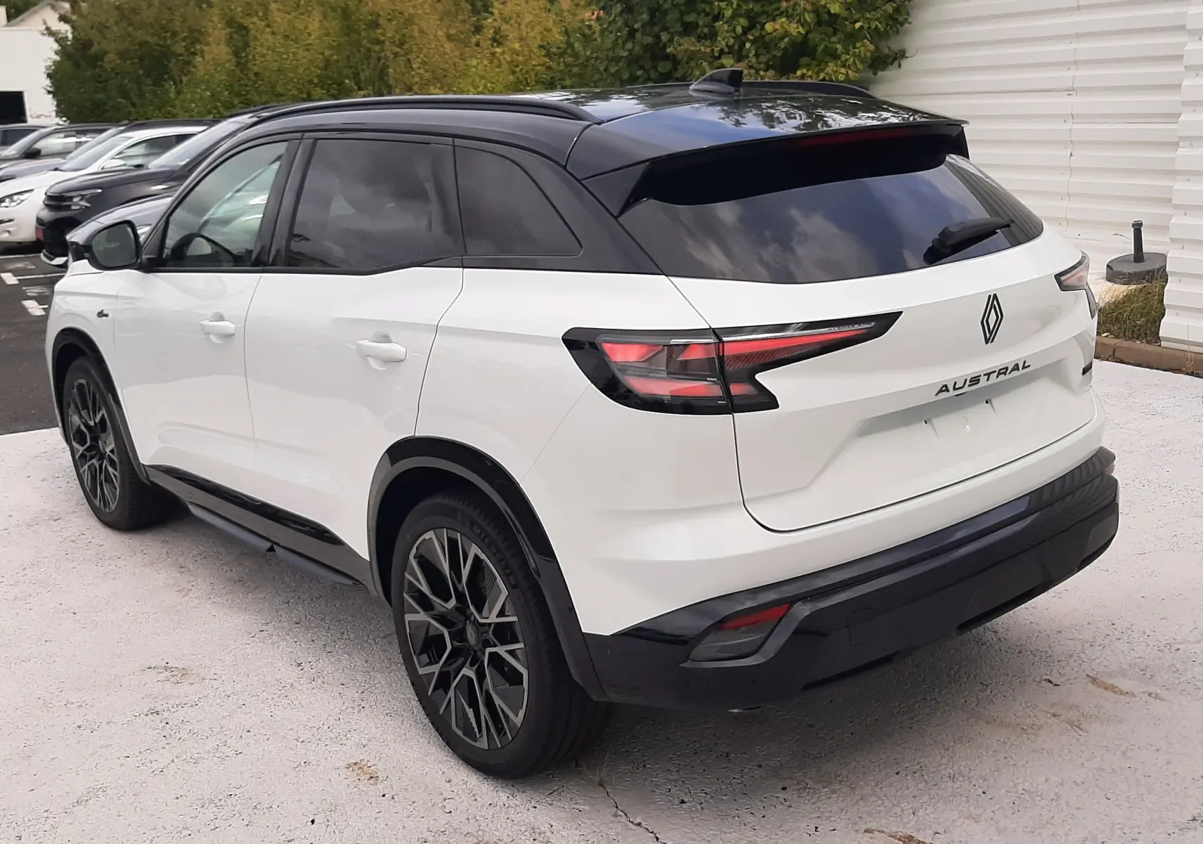 Vue 3/4 arrière droite du Renault Austral blanc nacré avec toit noir étoilé et jantes alliage noires diamantées.