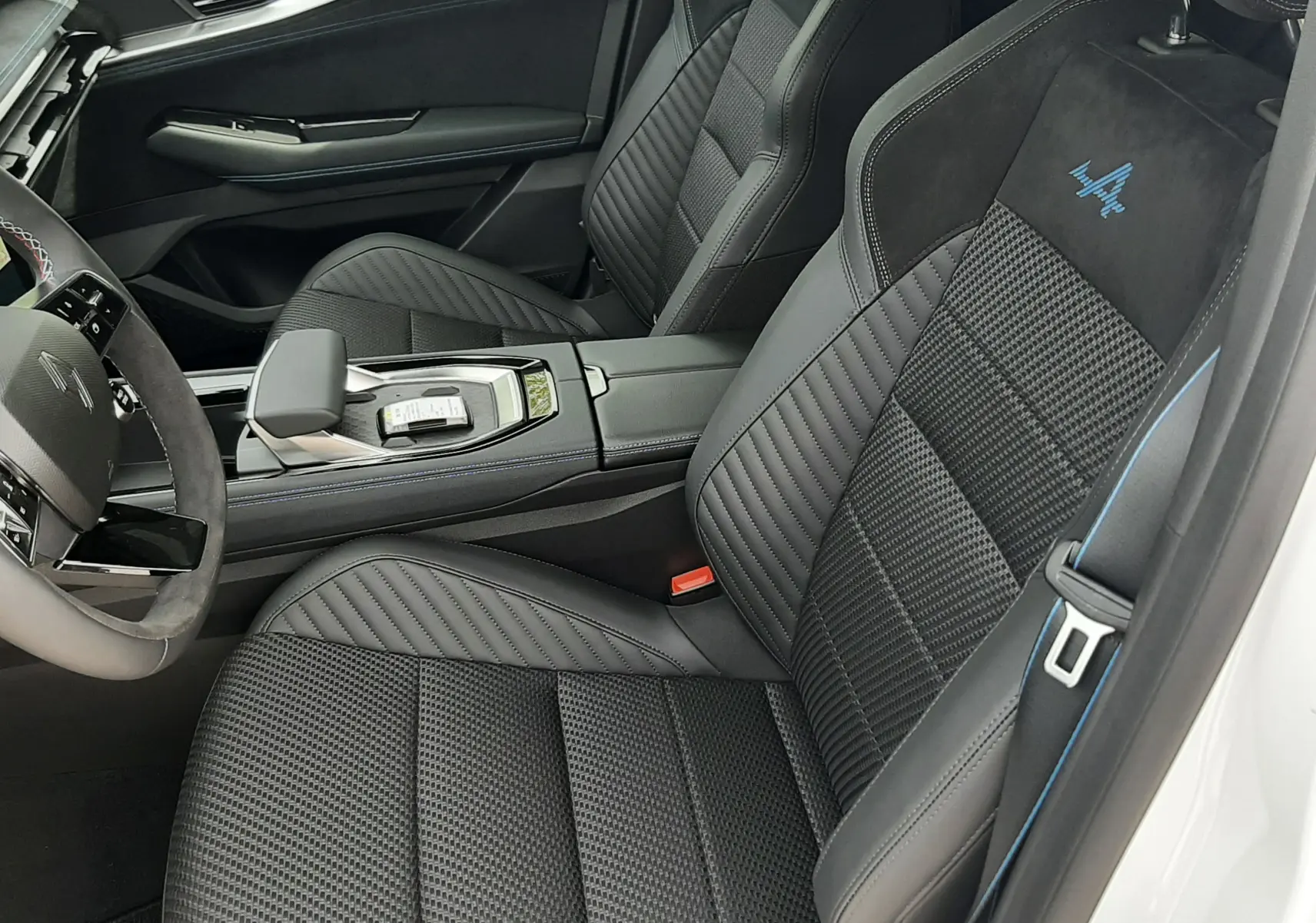 Vue intérieure côté droit du Renault Austral Esprit Alpine 2026, sièges noirs avec logo Alpine bleu brodé.
