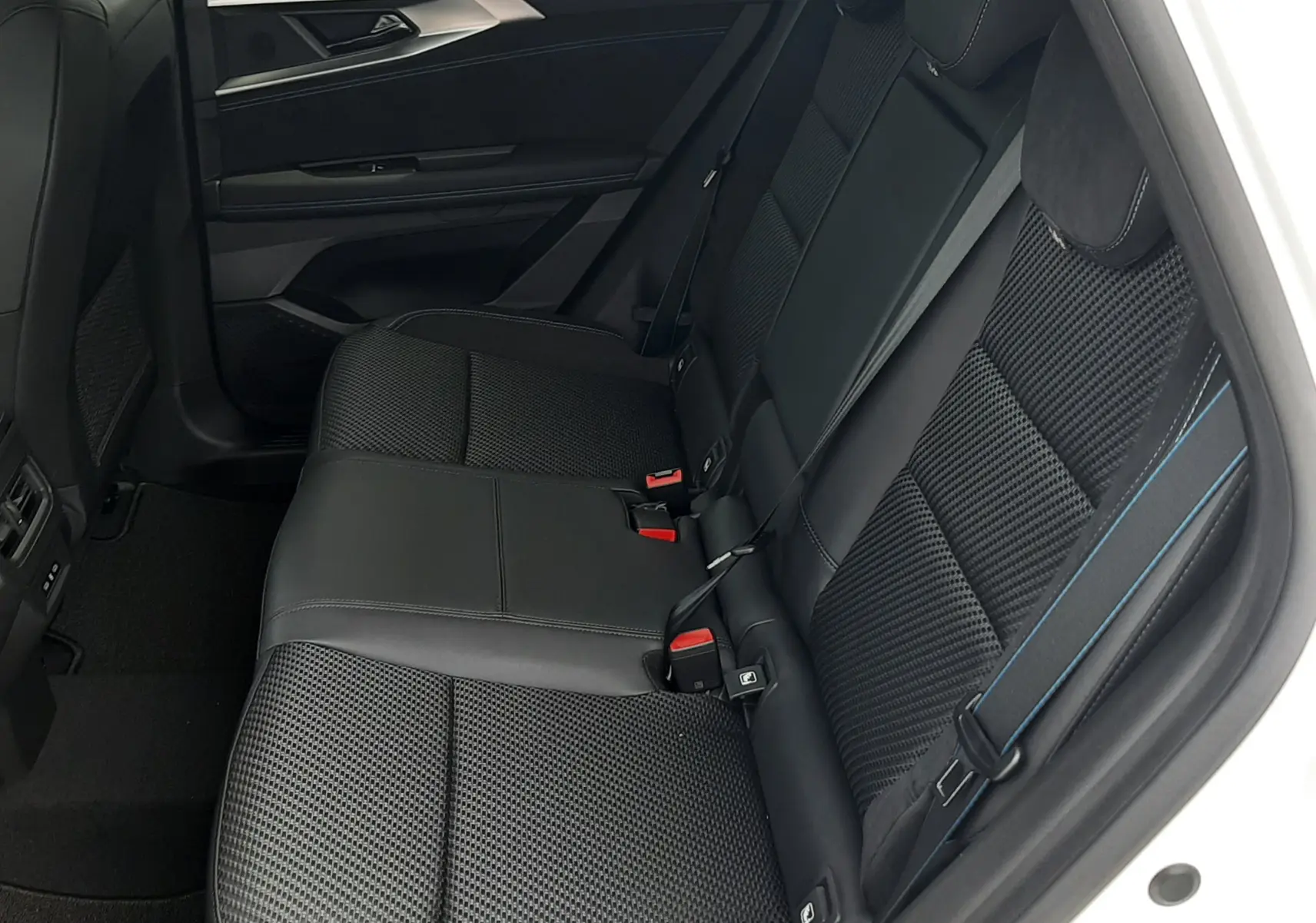 Vue intérieure côté droit de la banquette arrière noire en tissu Alcantara avec surpiqûres bleues du Renault Austral 2026.