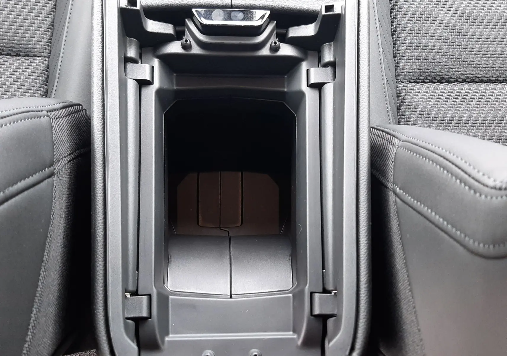 Vue plongeante sur la console centrale noire ouverte du Renault Austral Esprit Alpine avec sellerie tissu carbone Alcantara.
