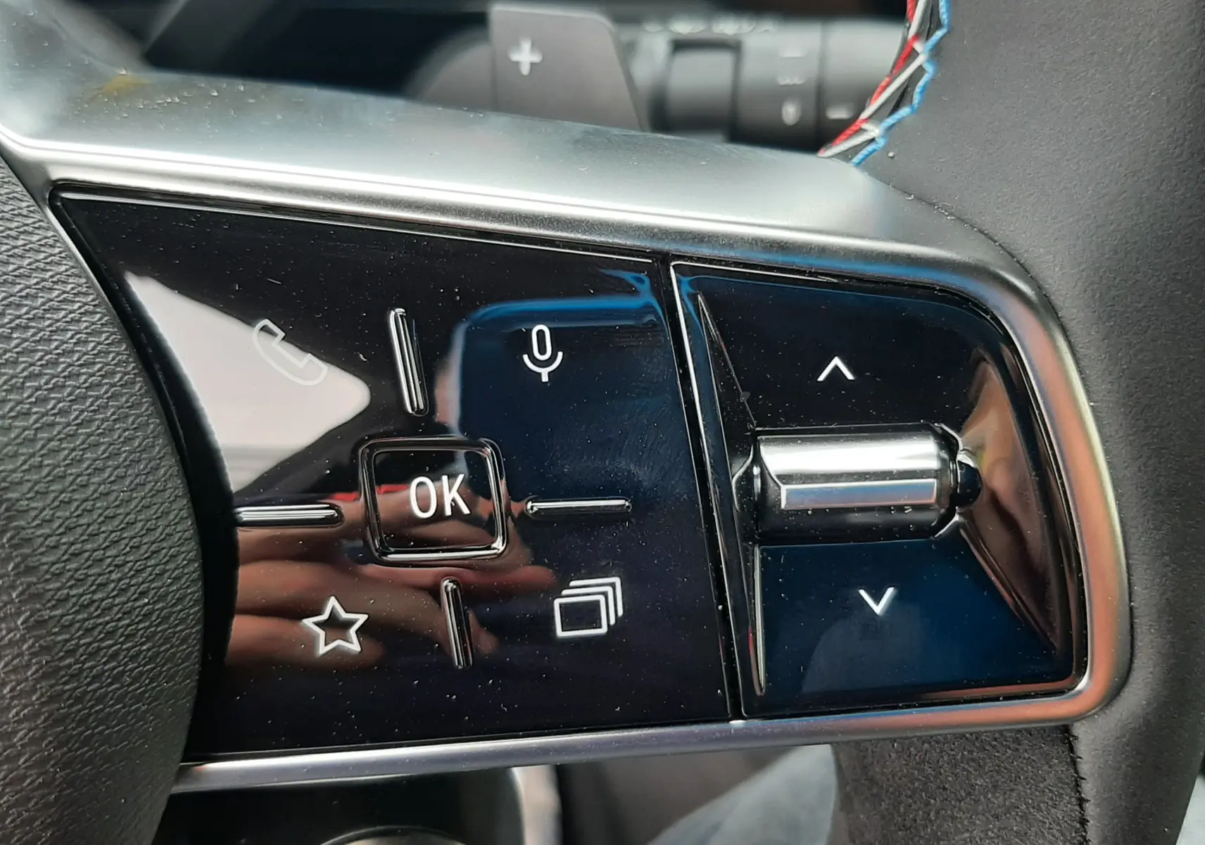 Gros plan sur les commandes multifonctions noires à droite du volant du Renault Austral blanc nacré.