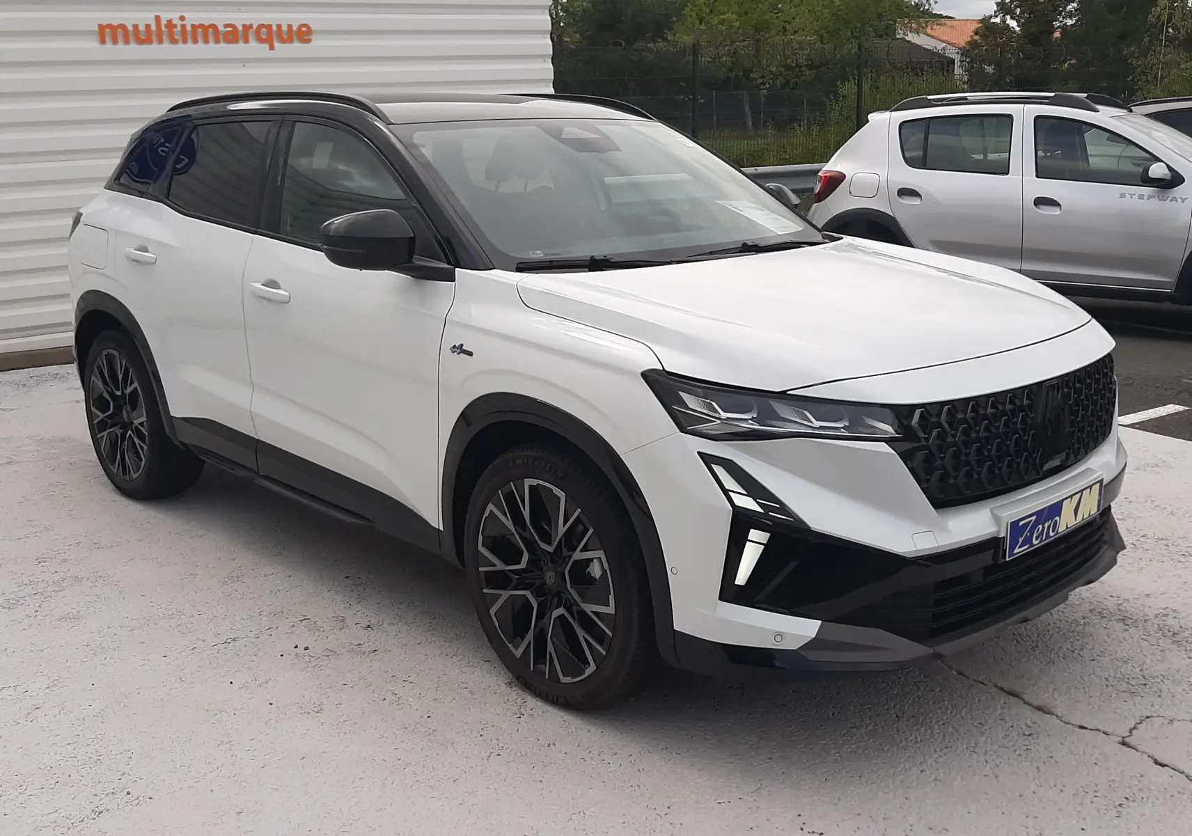 Renault Austral blanc nacré 3/4 avant droit avec toit noir étoilé et jantes alliage 20'' Altitude diamanté noir.