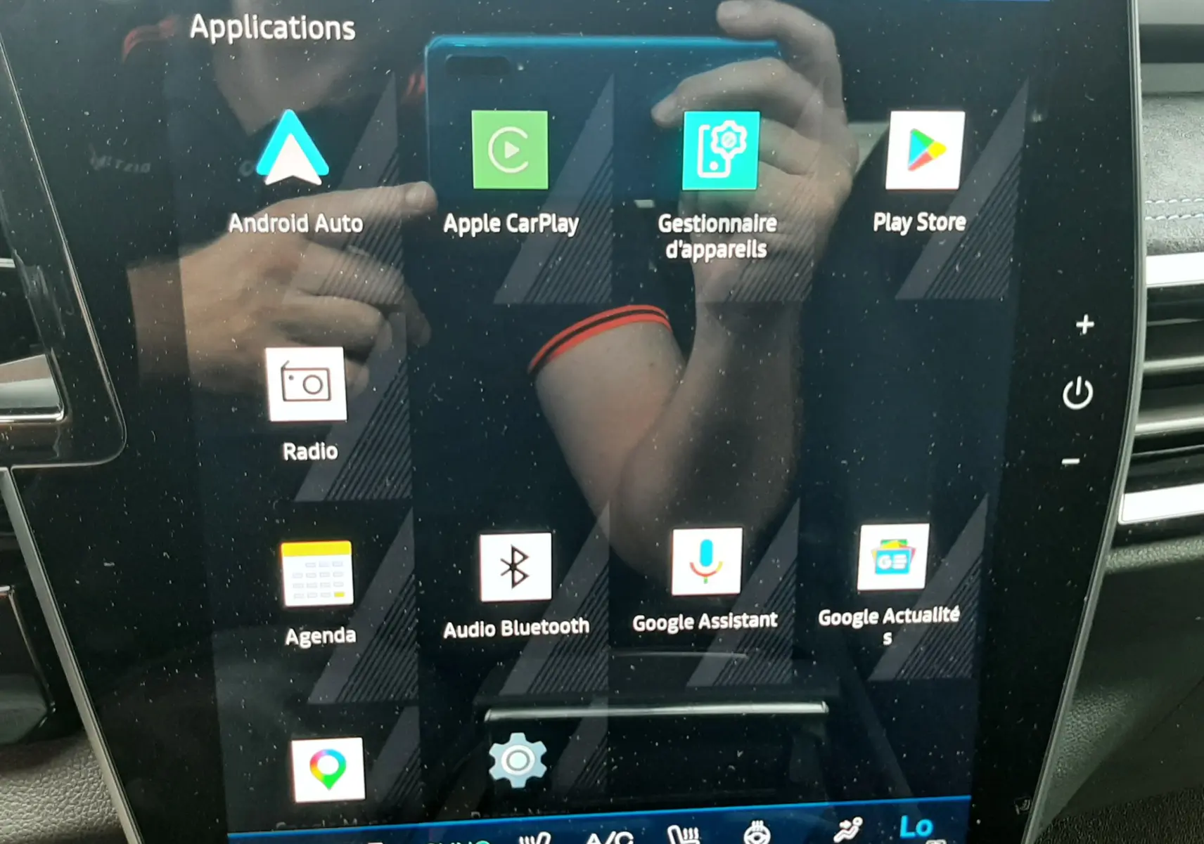 Écran tactile central du Renault Austral 2026 affichant les applications multimédia avec reflet intérieur du véhicule.