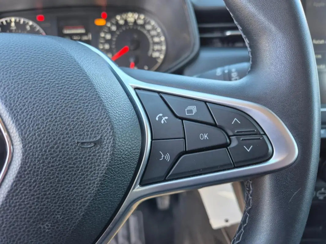 Gros plan sur les commandes multifonctions à droite du volant noir de la Renault Clio V TCe 90 Equilibre 2023.
