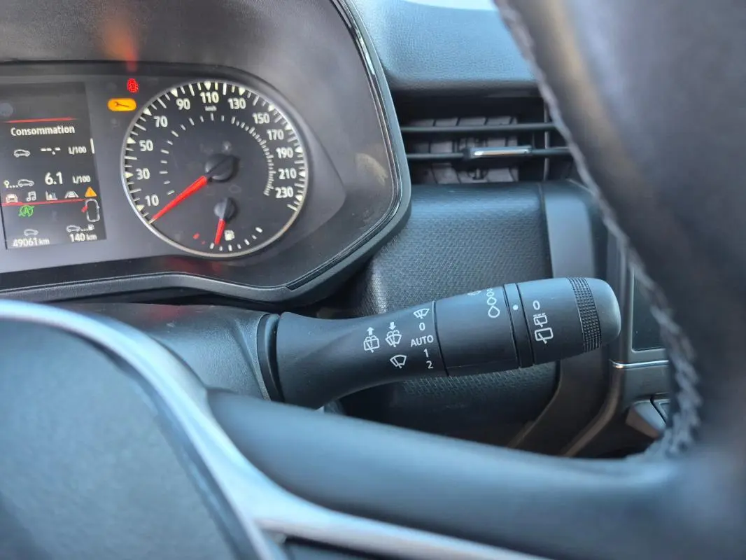 Vue rapprochée du tableau de bord et du commodo de la Renault Clio bleu foncé 2023, avec affichage consommation et vitesse.