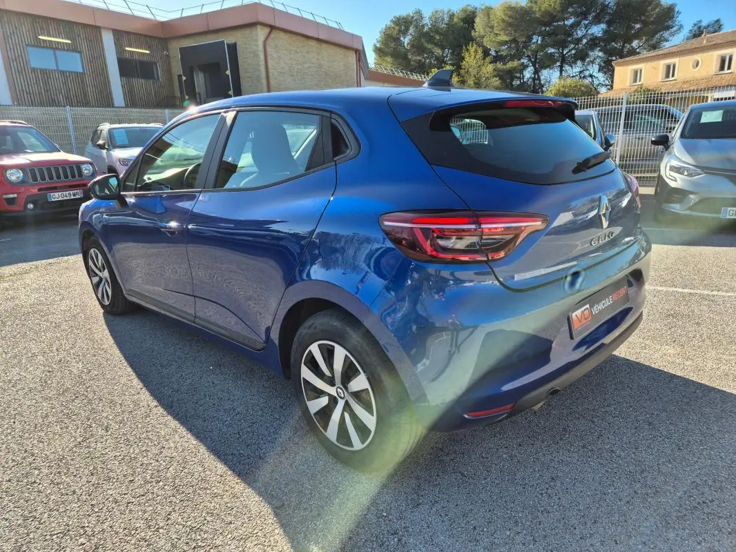 Renault Clio V TCe 90 bleu foncé vue 3/4 arrière droit, avec feux arrière LED et jantes alliage bicolores.