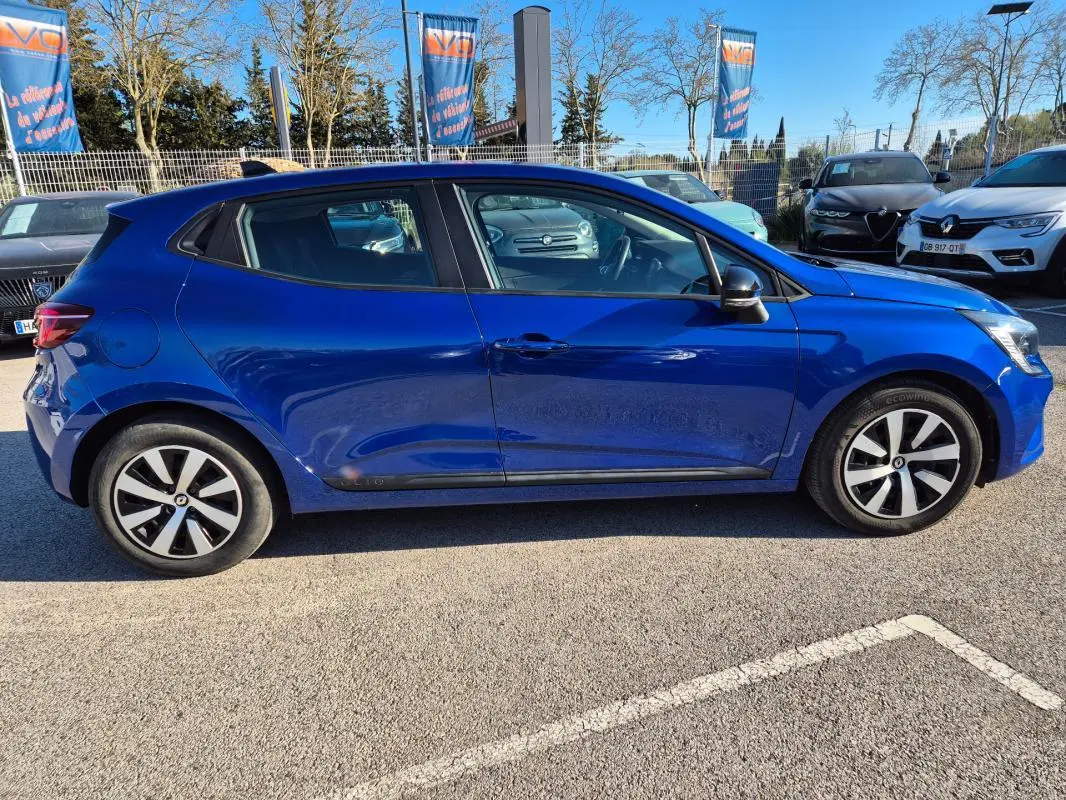 Profil côté gauche d'une Renault Clio V TCe 90 Équilibre bleu foncé 2023, avec jantes alliage et vitres teintées.