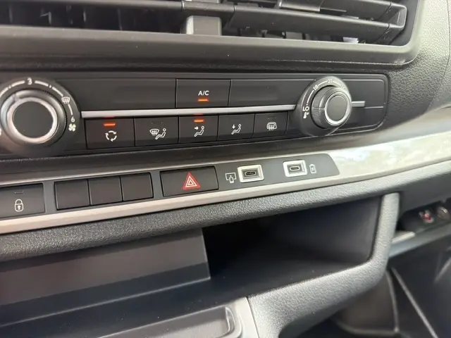 Détail de la console centrale du Citroën Jumpy blanc, montrant les commandes de climatisation et ports USB.