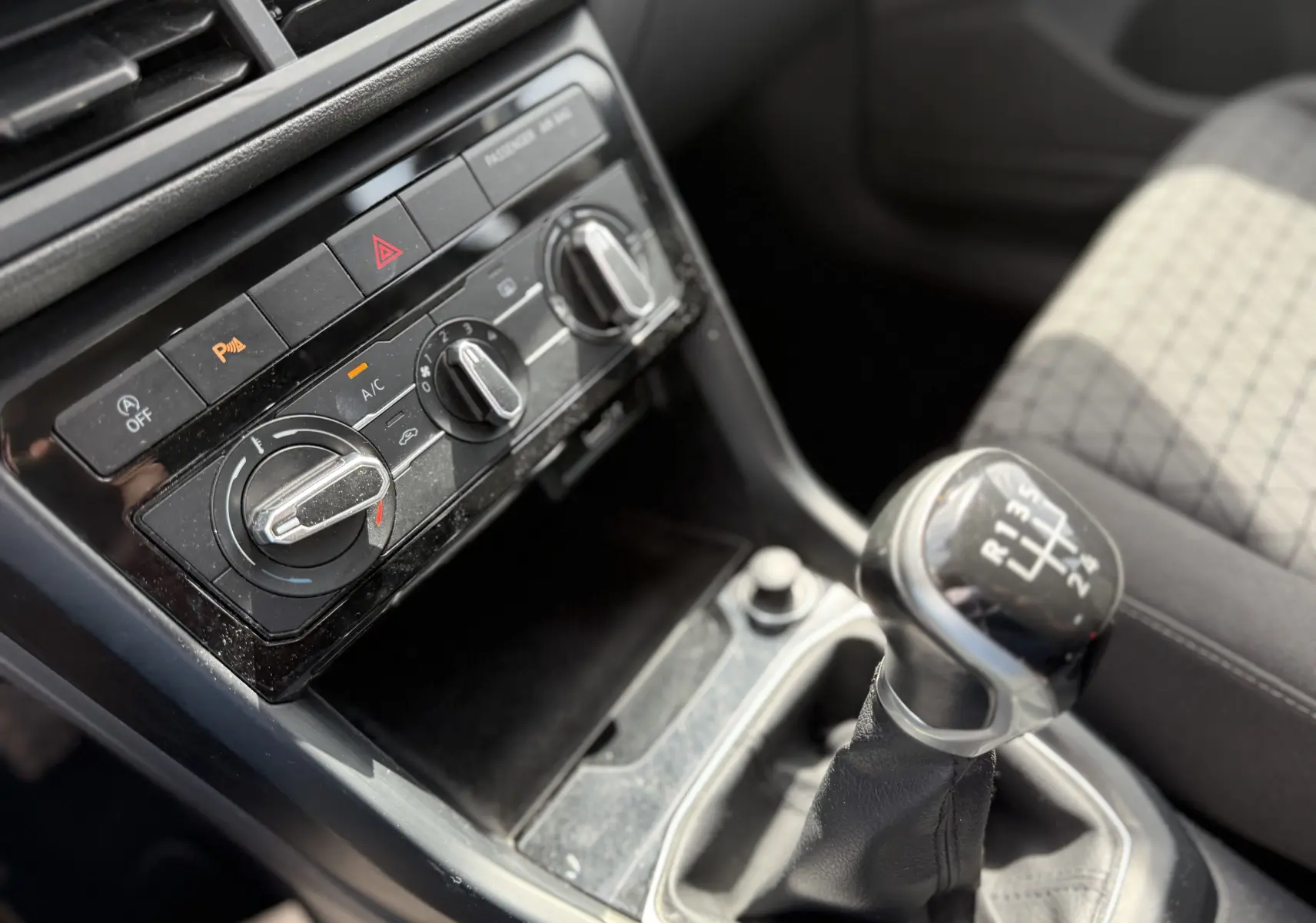 Gros plan intérieur sur la console centrale et levier de vitesses manuel d’un Volkswagen T-Cross gris 2019.