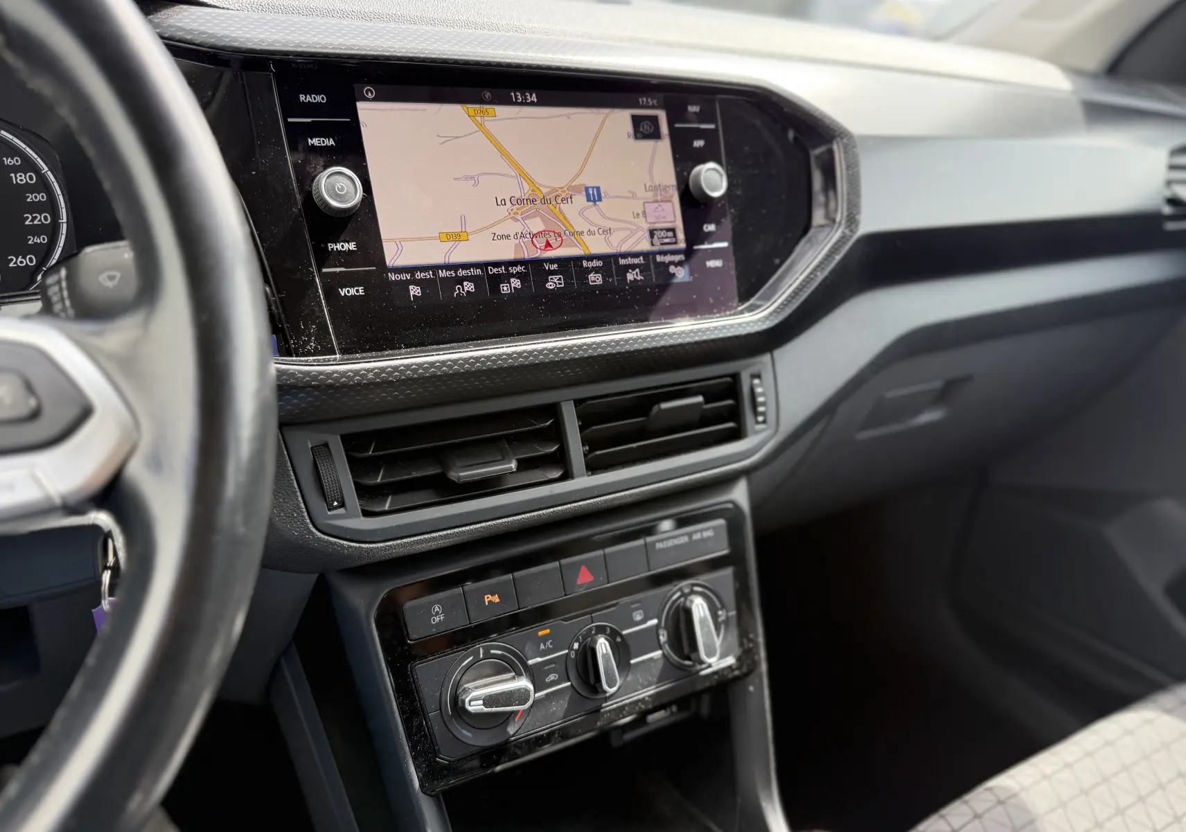 Vue intérieure du tableau de bord du Volkswagen T-Cross 1.6 TDI 95 Lounge Business 2019, avec écran tactile et commandes climatisation.