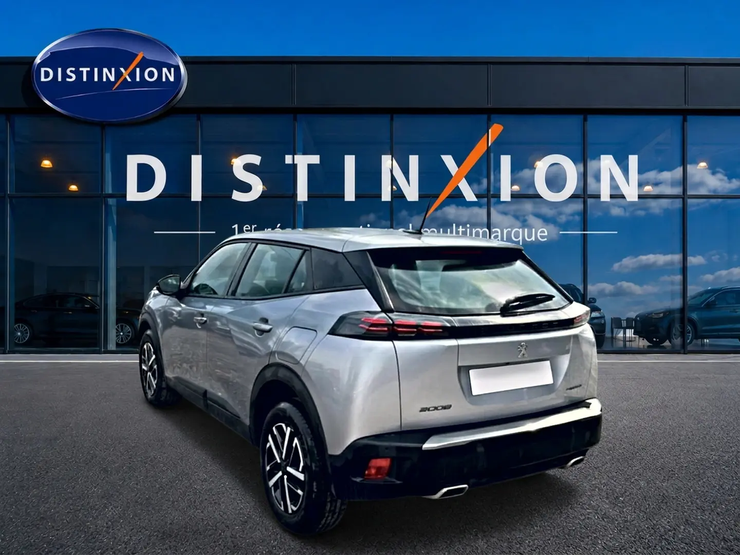 Vue 3/4 arrière droite d’un Peugeot 2008 gris 2025 avec feux arrière à LED et becquet noir.