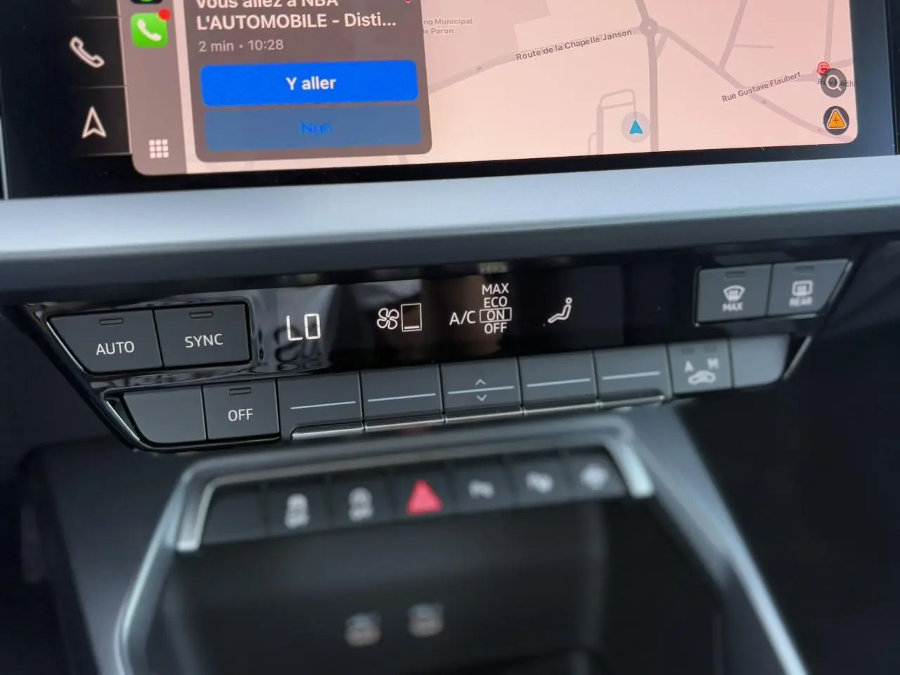 Gros plan sur la console centrale de l'Audi A3 Sportback 2024, affichant les commandes climatisation et écran tactile.