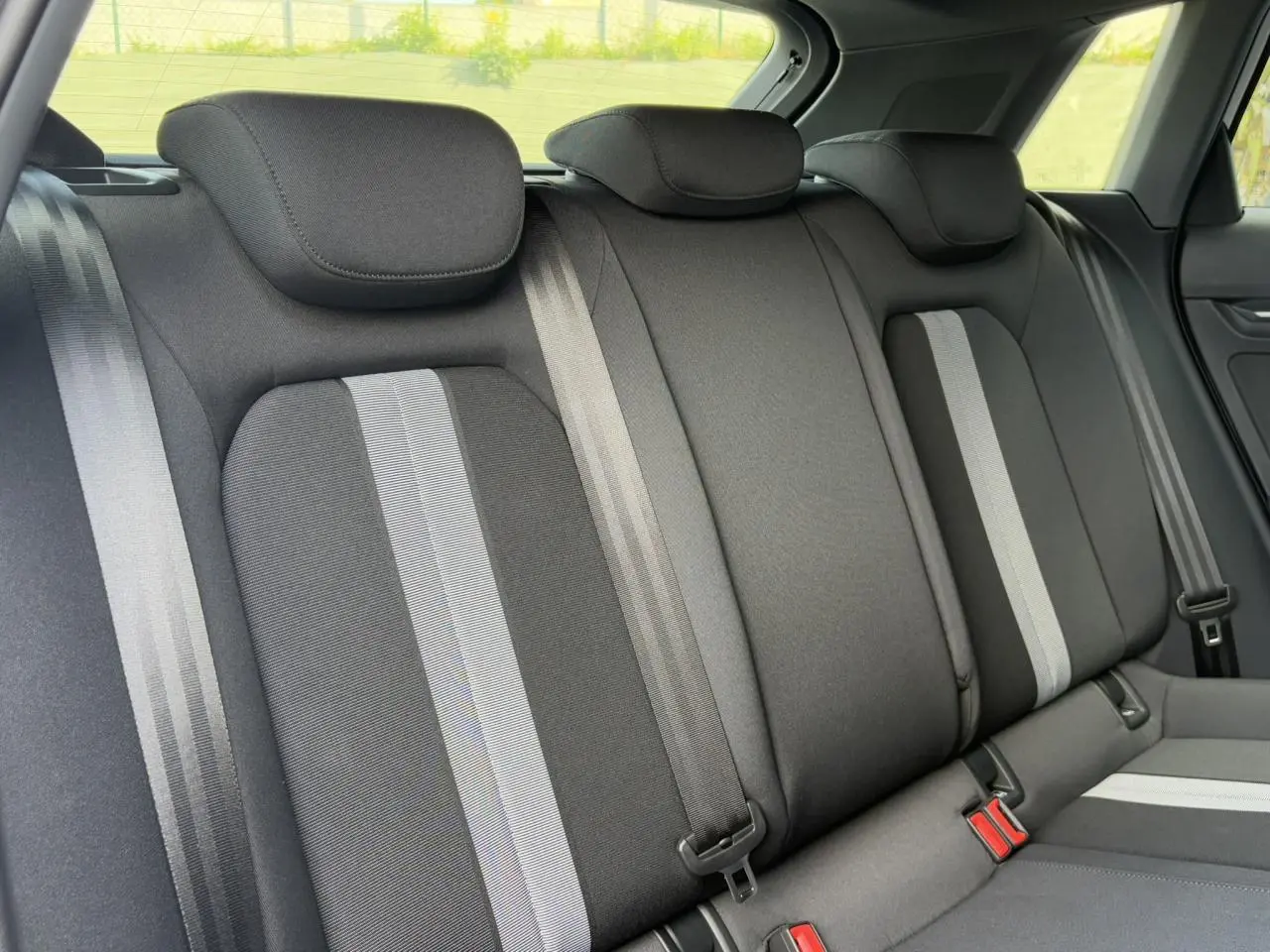 Vue rapprochée des sièges arrière noirs avec bandes grises de l'Audi A3 Sportback 2024 Blanc Arkona.
