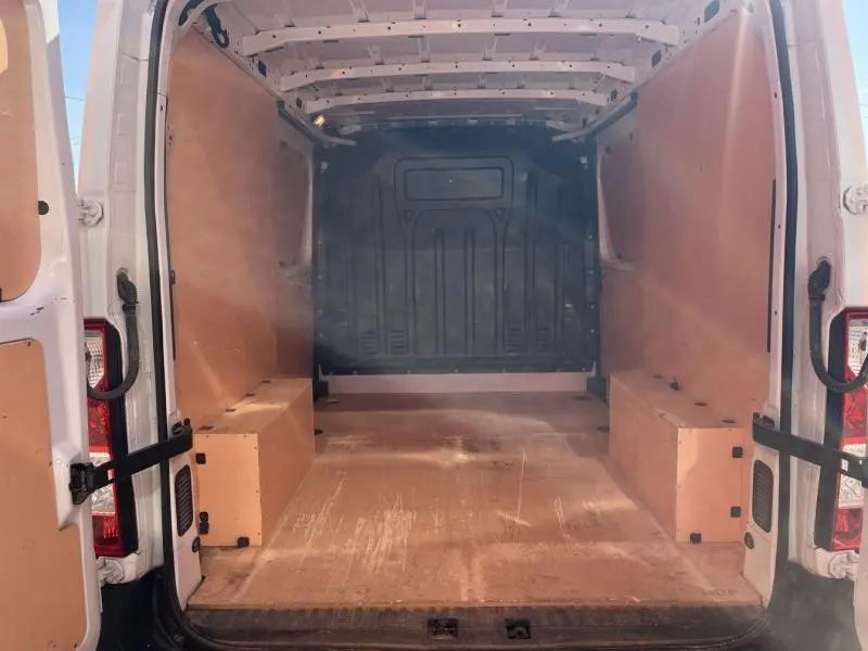 Vue arrière ouverte du Renault Master blanc glacier 2018 montrant l'espace de chargement vide avec cloison pleine et habillage bois.