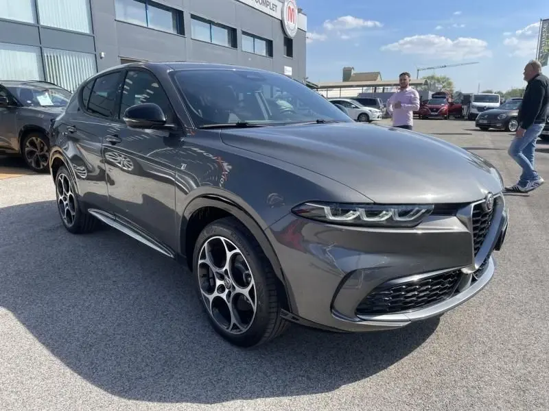 Vue 3/4 avant droite de l'Alfa Romeo Tonale gris foncé métal 2023, avec ses phares LED et jantes distinctives à cinq cercles.