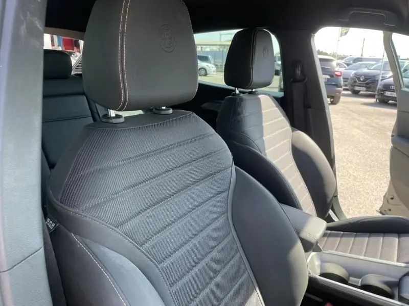 Gros plan sur les sièges avant noirs de l'Alfa Romeo Tonale 2023, avec logo embossé sur les appuie-têtes.