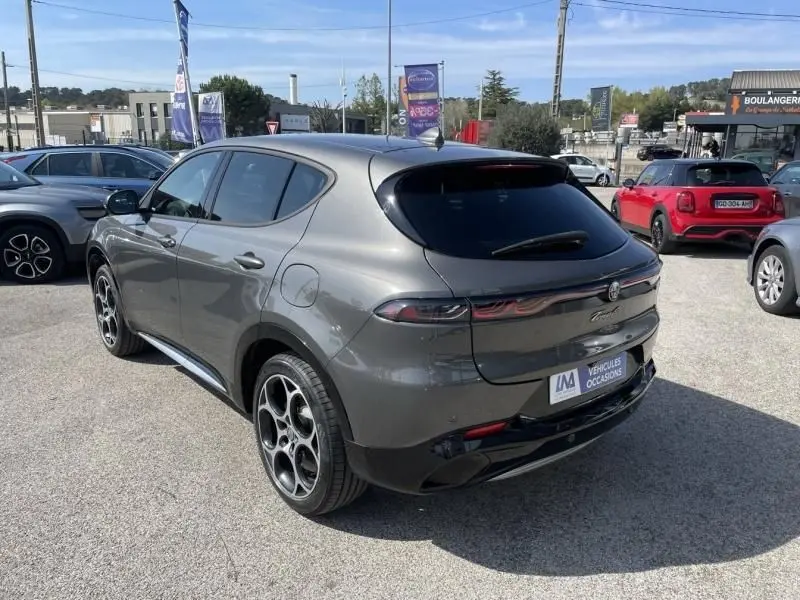 Vue 3/4 arrière droite de l'Alfa Romeo Tonale gris foncé métal, avec jantes distinctives et vitres teintées.