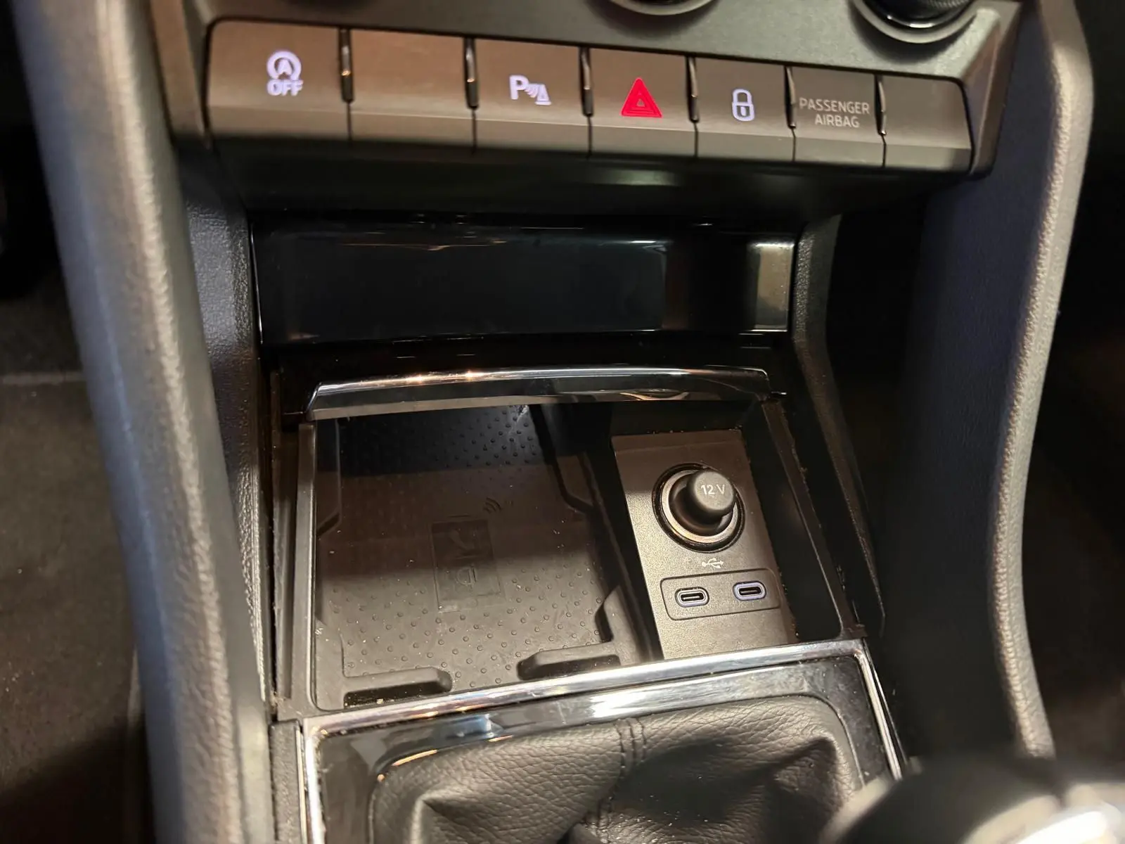 Gros plan intérieur sur la console centrale du Skoda Karoq blanc 2023, montrant prises USB, prise 12V et boutons de contrôle.