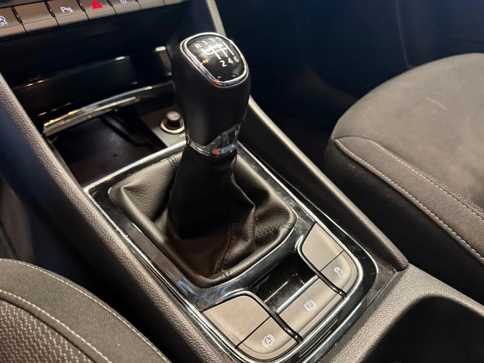 Le levier de vitesses manuel noir du Skoda Karoq 2023, avec console centrale et sièges en tissu gris foncé.