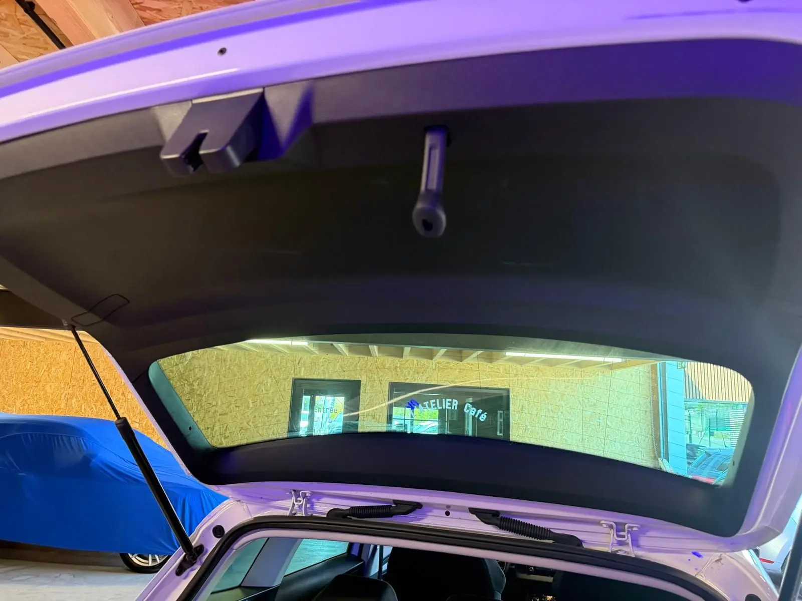 Vue arrière ouverte sur le coffre d’un Skoda Karoq blanc 2023, version 1.5 TSI Ambition Phase 2, en intérieur.