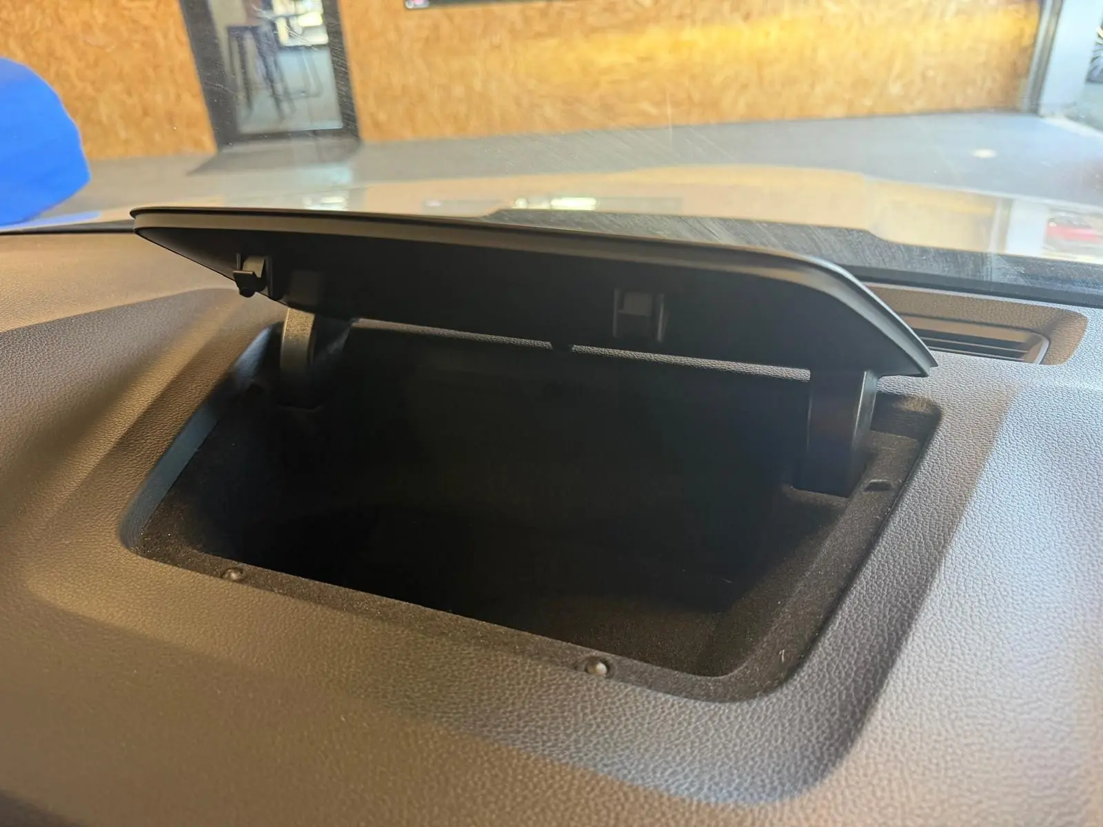 Coffre de rangement ouvert sur le tableau de bord d’un Skoda Karoq blanc, vue intérieure rapprochée.