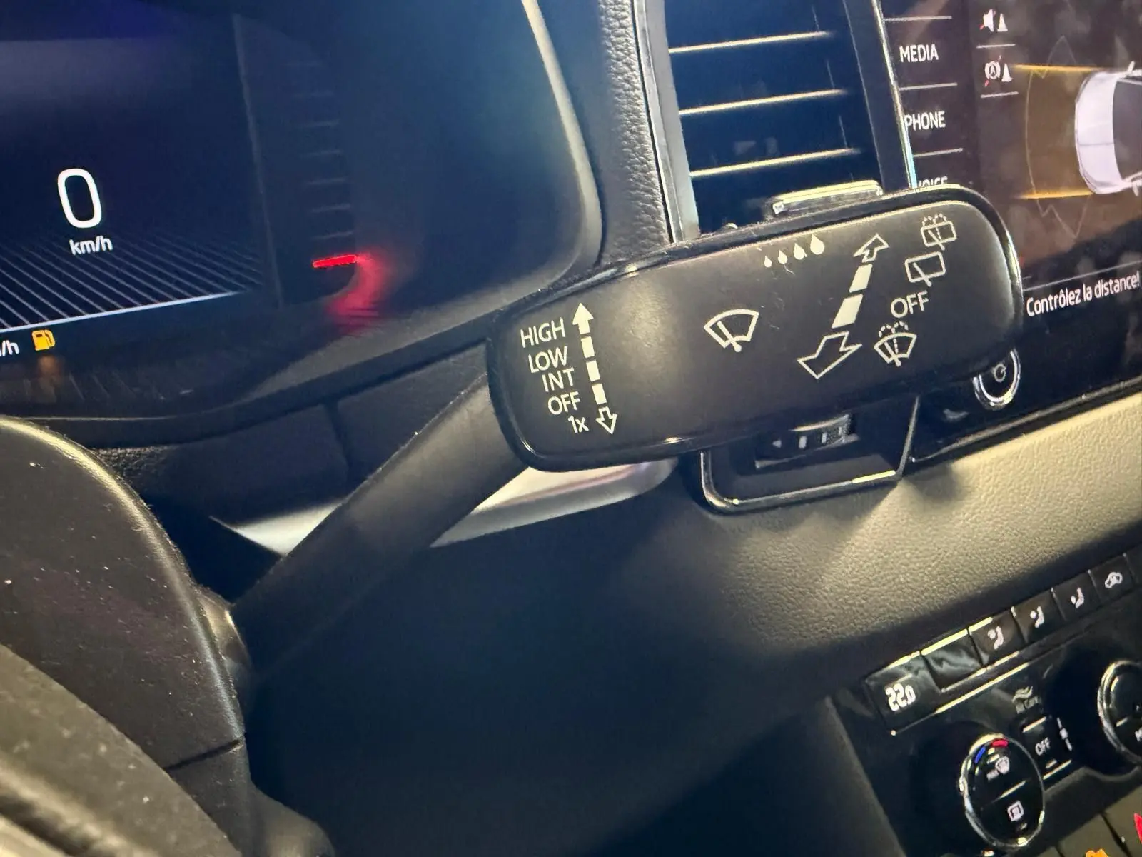 Gros plan sur la commande d’essuie-glace du tableau de bord noir du Skoda Karoq blanc 2023, version essence.