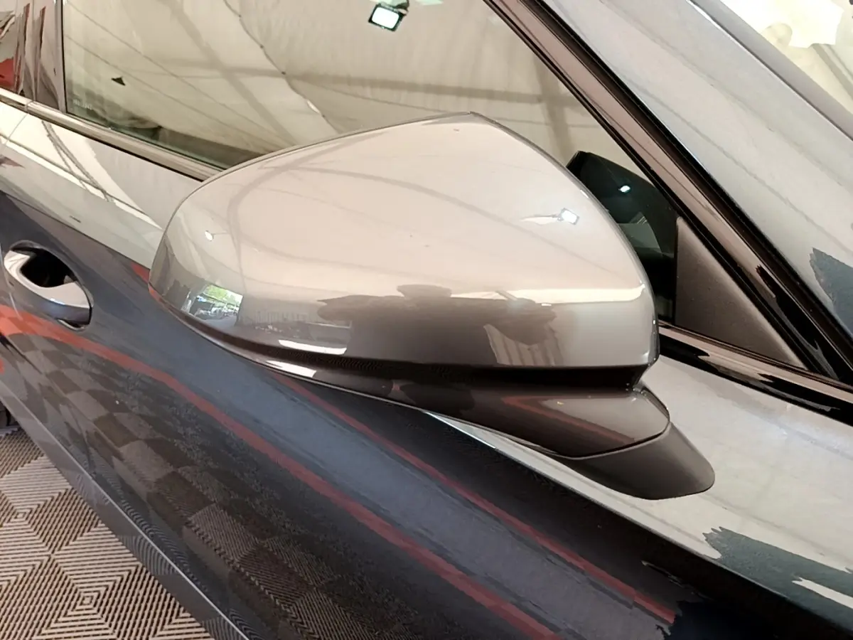Gros plan sur le rétroviseur côté gauche gris foncé du CUPRA Formentor 2022, avec poignée de porte visible.