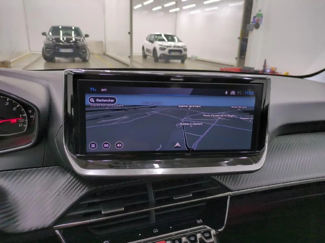 Vue intérieure centrée sur l'écran tactile 10'' du tableau de bord de la Peugeot 208 gris clair, avec navigation affichée.