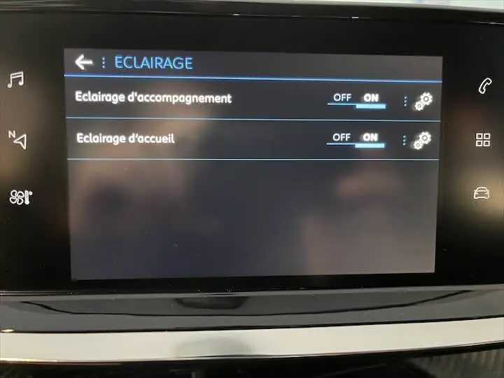 Écran tactile intérieur de la Peugeot 208 affichant les réglages d'éclairage d'accompagnement et d'accueil activés.