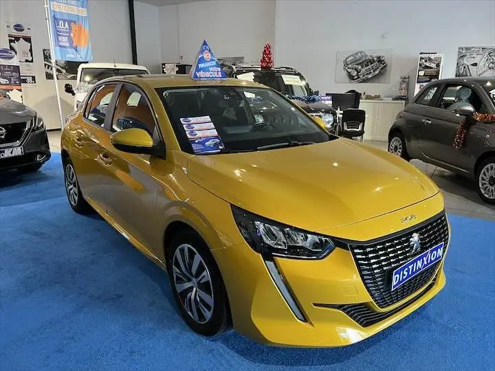 Peugeot 208 jaune Faro Metal vue 3/4 avant droit en showroom avec plaque Distinxion visible