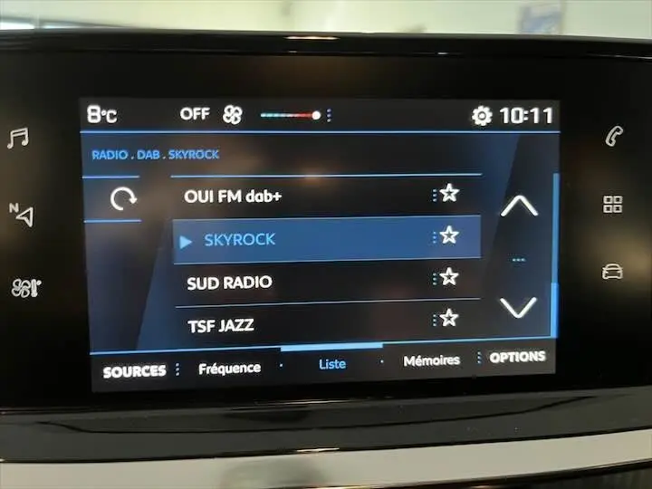 Écran tactile multimédia de la Peugeot 208 affichant la liste des radios DAB avec Skyrock sélectionné.