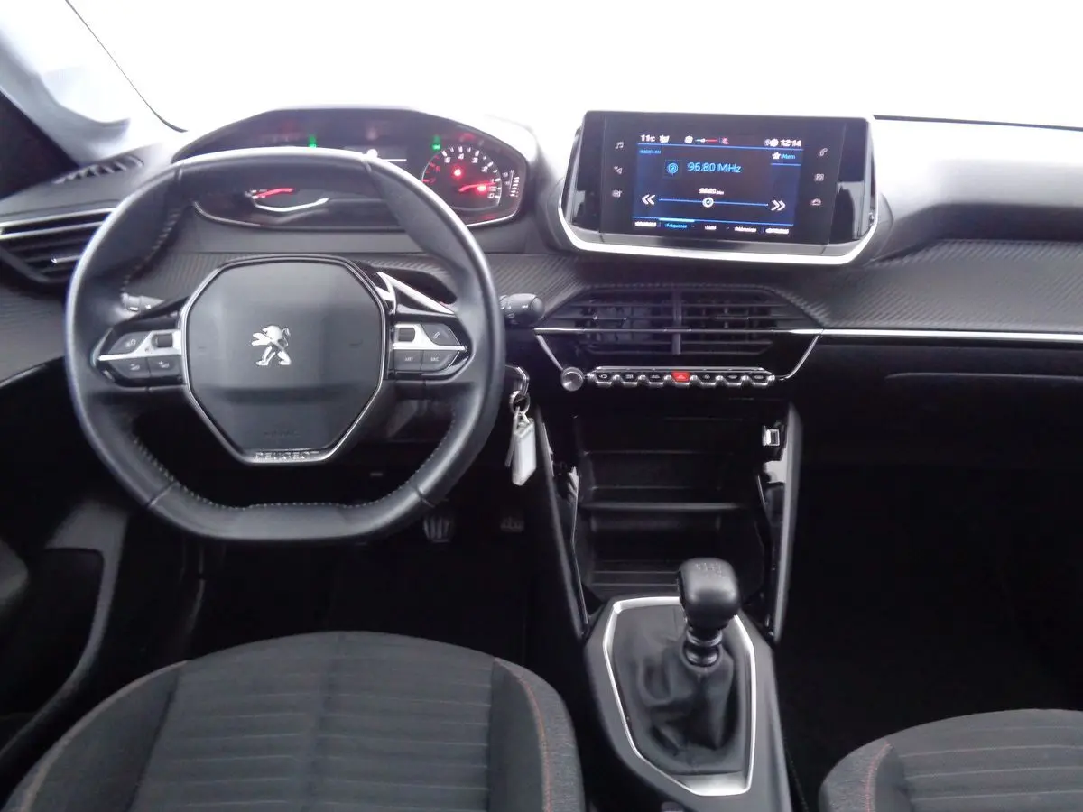 Intérieur Peugeot 208 2020 vu de face, tableau de bord moderne avec écran tactile et volant compact noir.